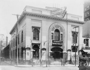 a black and white photograph of Dumont's Minstrel theater advertising burlesque shows